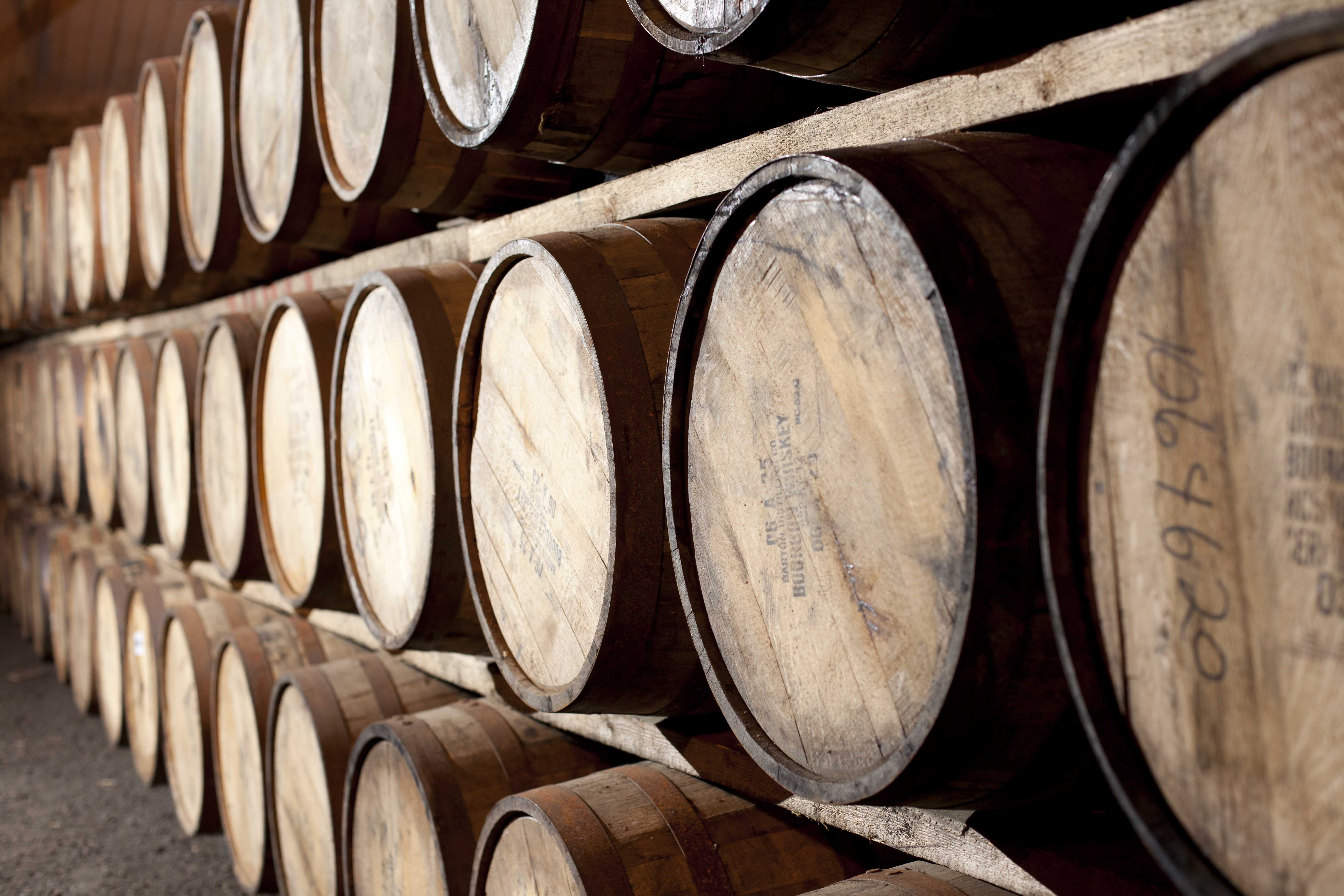 Casks of whisky stacked on each other in a dunnage style within a warehouse